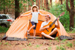 © Svetlana - Father and daughter near camping tent playing guitar in summer forest