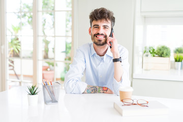 Sticker - Young business man talking on smartphone with a happy face standing and smiling with a confident smile showing teeth