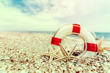 lifebuoy with starfish on beach at sea coast