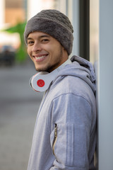 Wall Mural - Smiling young latin man sports training with headphones portrait format