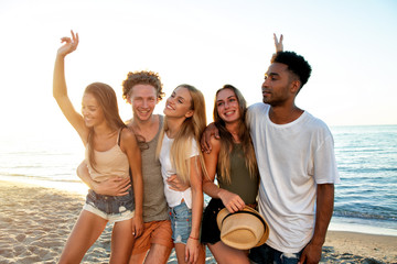 Group of friends having fun on the beach. Concept of summertime