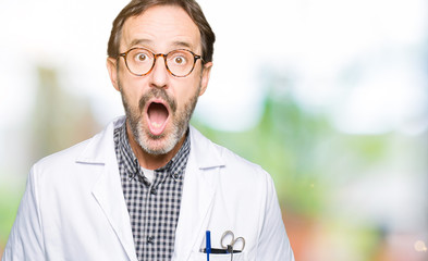 Poster - Middle age doctor men wearing medical coat afraid and shocked with surprise expression, fear and excited face.