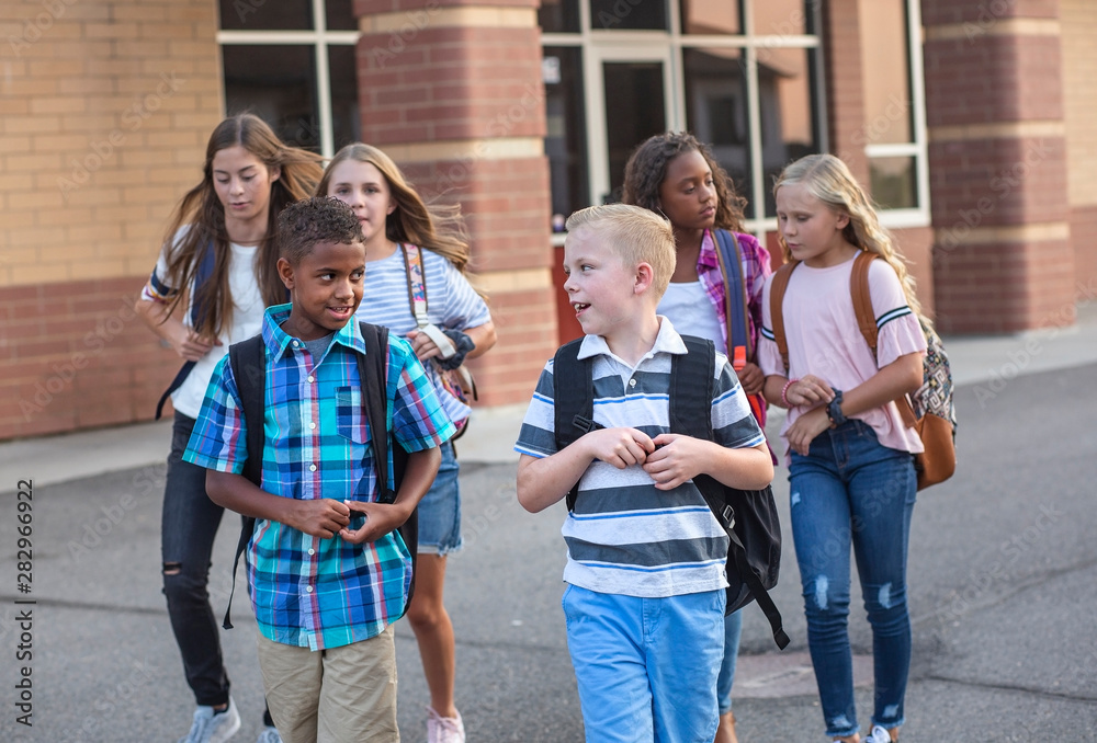 Large, diverse group of kids leaving school at the end of the day ...