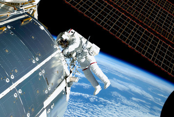 the astronaut in an outer space, at the iss, repairs and makes experiments. elements of this image w