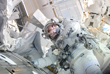 Wall Mural - the astronaut in a space suit, in the iss, lasts a hand in the camera. elements of this image were f