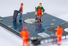 Miniature Workers Cleaning A Broken Hard Drive And Recycle It