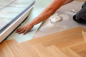 Wall Mural - Worker laying parquet flooring. Worker installing wooden laminate flooring