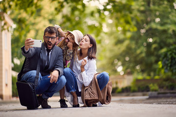 Wall Mural - first day at school, parents and girl making a photo in front of school