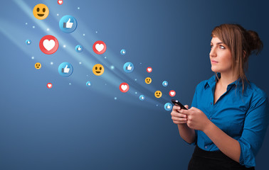 Young person using smartphone with flying social media icons around