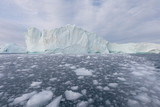 Fototapeta Morze - Nature and landscapes of Greenland or Antarctica. Travel on the ship among ices. Studying of a phenomenon of global warming Ices and icebergs of unusual forms and colors Beautiful sunny and cloudy day