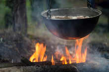 Pot With Meat Stew, Boiling On Bonfire Flame, In A Tourist Camp In The Wild Forest