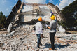 © skarie - Demolition control supervisor and contractor discussing on demolish building.