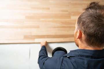 Wall Mural - A Male Worker install wood floor on a house