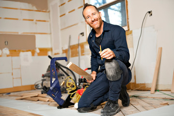 Wall Mural - A Male Worker install wood floor on a house