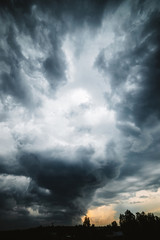dramatic cloudscape. sunny light through dark heavy thunderstorm clouds before rain. overcast rainy 