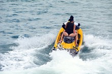 Young Couple Riding Tandem On A Yellow Jet Ski