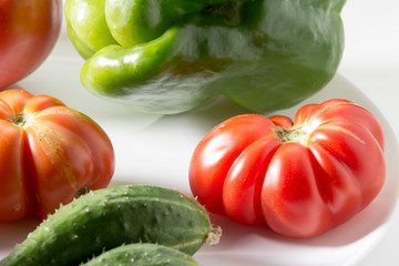 Ugly freak organic tomato and cucumber and pepper on a white background. The concept of organic vegetables.