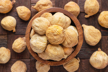 dried figs in wooden bowl, top view.