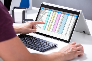 Aufkleber - Businessman's Hand Examining Spreadsheet On Laptop In Office