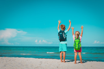 Wall Mural - happy kids with backpacks enjoy travel on beach