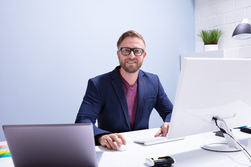 Young Businessman Sitting In Front Of Computer