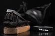 Black shoe polish, brush and shoes on the table. Accessories for cleaning leather footwear.