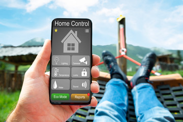 Man Lying In Hammock Using Smart Home App