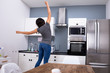 © Andrey Popov - Woman Jumping In The Kitchen