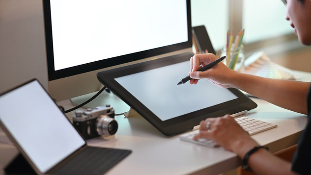 Young graphic designer working with pen and tablet, young artist working with creative workplace.