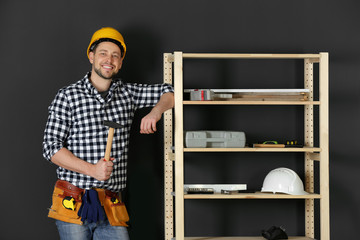 Sticker - Handsome working man in hard hat with hammer indoors. Home repair