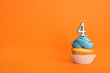 © New Africa - Birthday cupcake with number four candle on orange background, space for text