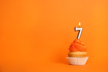 Birthday Cupcake With Number Seven Candle On Orange Background, Space For Text