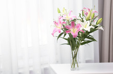 Vase With Bouquet Of Beautiful Lilies On White Table Indoors. Space For Text