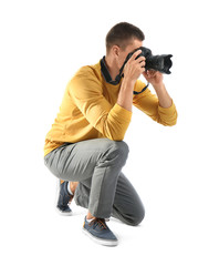 Young professional photographer taking picture on white background