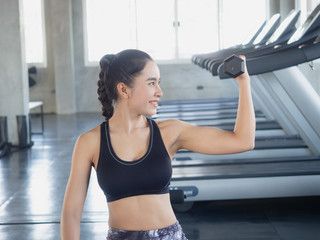 asian woman is exercising with a dumbbell in gym