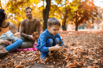 Wall Mural - Happy family of four having fun together in the park in autumn