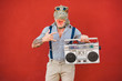 Crazy senior man dancing rock music wearing t-rex mask - Tattoo trendy guy having fun listening music with boombox stereo - Absurd and funny trend concept - Focus on face