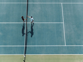 Tennis players shaking hands over the net