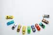 © adragan - Many colored little toy cars on a gray background.