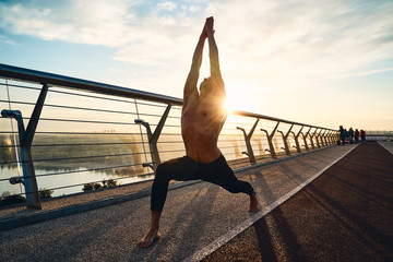 Wall Mural - Young man doing exercise early in the morning on a pathway