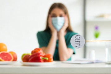 Wall Mural - selective focus of woman in medical mask propping face with hands and nameplate with inscription allergy