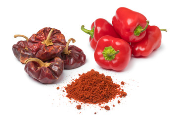 Dried and fresh red bell peppers and a heap of powder