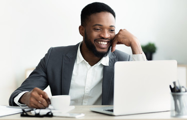 Poster - African businessman making video call to family during coffee break