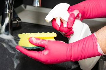 Wall Mural - The process of washing the sink, hands closeup. Putting detergent on the dish sponge. Cleaning.