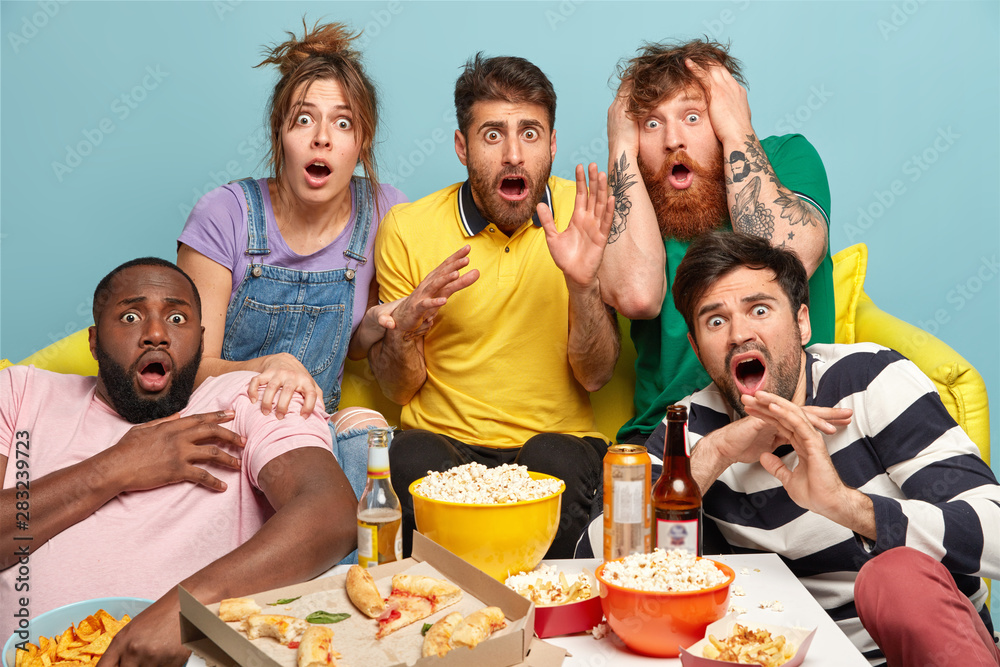Scared group of friends watch horror movie, feel great fear and ...