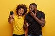 © wayhome.studio  - Horizontal shot of glad dark skinned female and male pose for making selfie portrait, take shot for posting in social networks, laugh happily, have perfect mood, isolated on yellow background