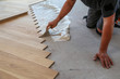 © leomalsam - Worker laying parquet flooring. Worker installing wooden laminate flooring