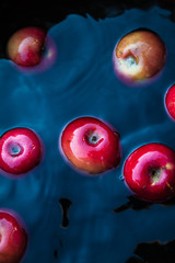 Sticker - Red juicy apples in the water in a bucket. Trending dark retro background. Concept, rich harvest. Top view.