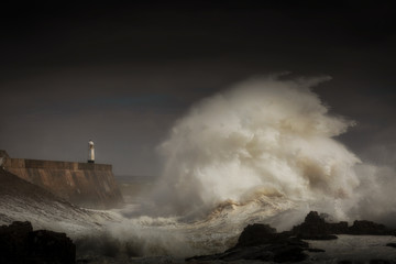  Porthcawl lighthouse and pier in the jaws of a storm on the coast of South Wales, UK.