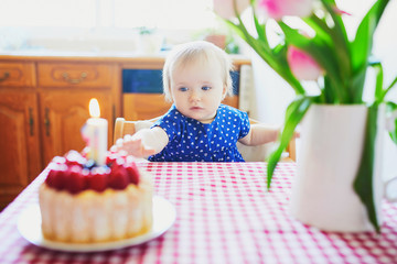 Wall Mural - Happy baby girl in blue dress celebrating her first birthday